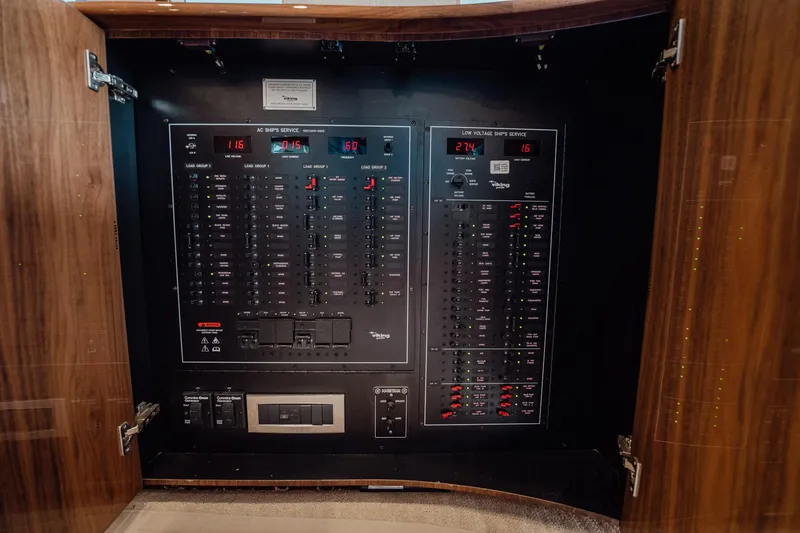 Slide: The Image of Electrical panel inside 2021 Viking 54 Convertible yacht, showcasing circuit breakers and controls. - 10