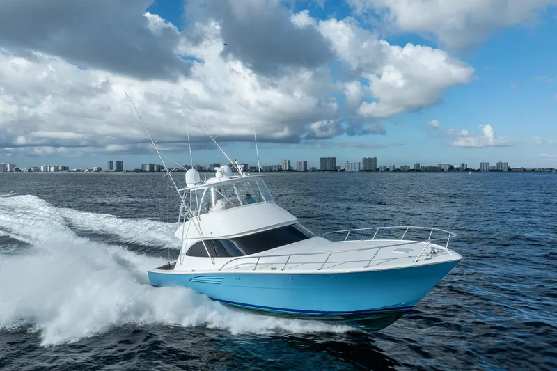 Slide: The Image of 2021 Viking 54 Convertible yacht cruising on open water under cloudy sky. - 108