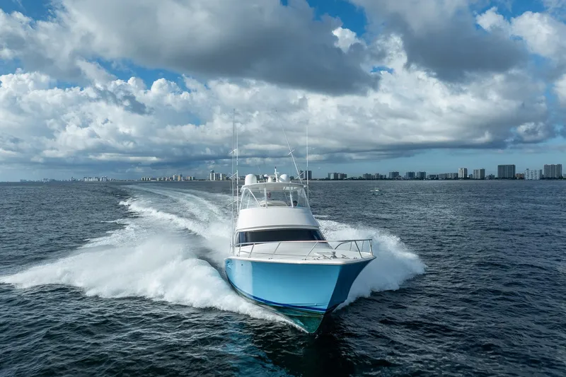 Slide: The Image of 2021 Viking 54 Convertible yacht cruising on open water under cloudy skies. - 109