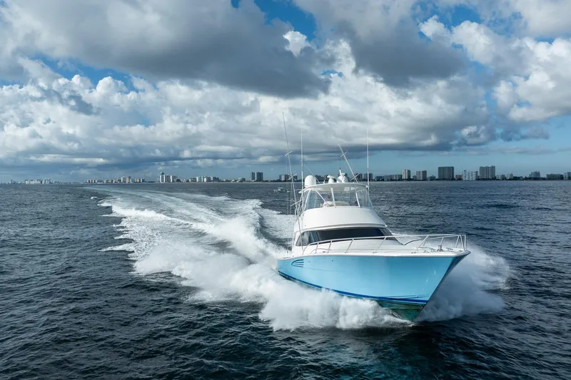 Slide: The Image of 2021 Viking 54 Convertible yacht cruising on open water under cloudy skies. - 110