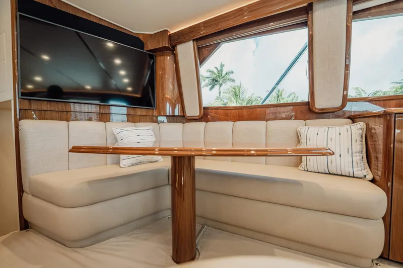 Slide: The Image of Luxurious interior of 2021 Viking 54 Convertible yacht with plush seating and large TV. - 14