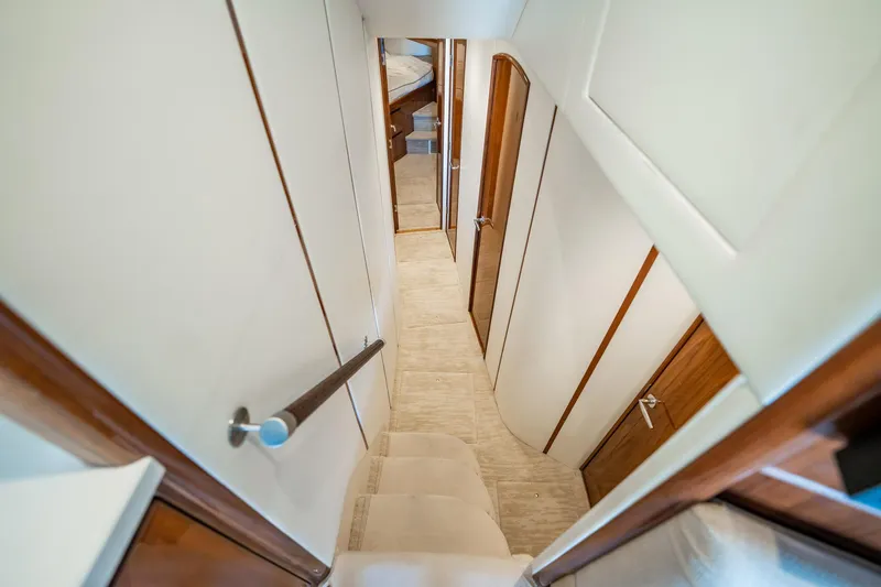 Slide: The Image of Interior hallway of 2021 Viking 54 Convertible yacht, featuring elegant wood finishes. - 23
