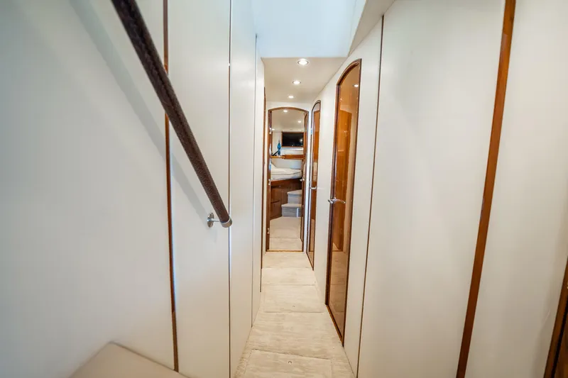 Slide: The Image of Interior hallway of 2021 Viking 54 Convertible yacht, featuring elegant wood accents. - 24