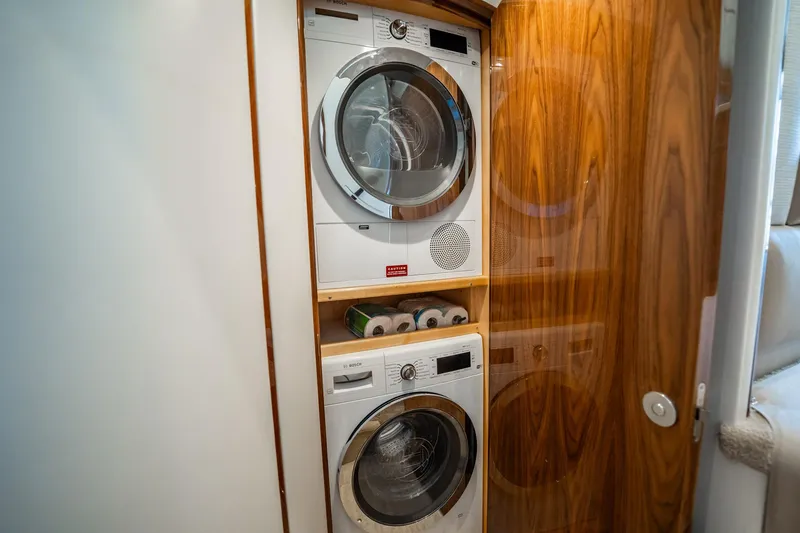 Slide: The Image of Laundry area with stacked washer and dryer in 2021 Viking 54 Convertible yacht. - 25
