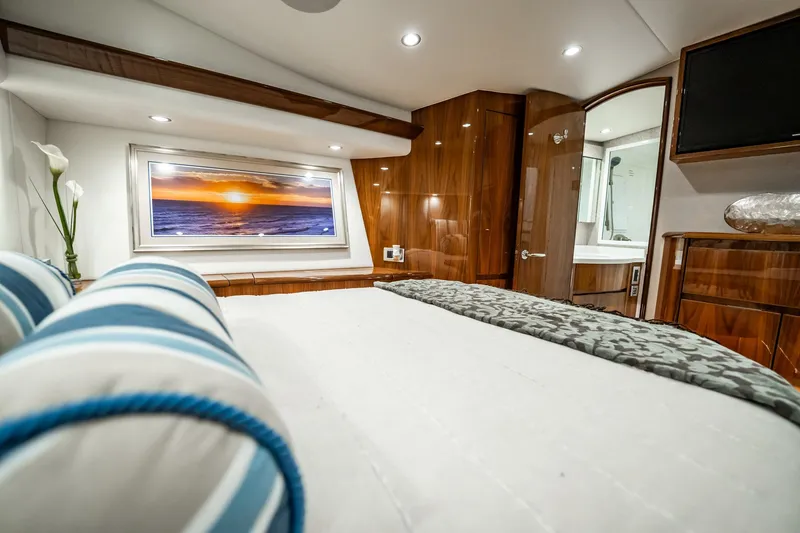 Slide: The Image of Luxurious bedroom interior of 2021 Viking 54 Convertible yacht with elegant wood finishes. - 30