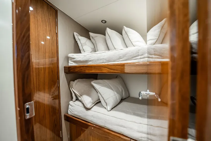 Slide: The Image of 2021 Viking 54 Convertible yacht interior with cozy bunk beds and wooden finish. - 46