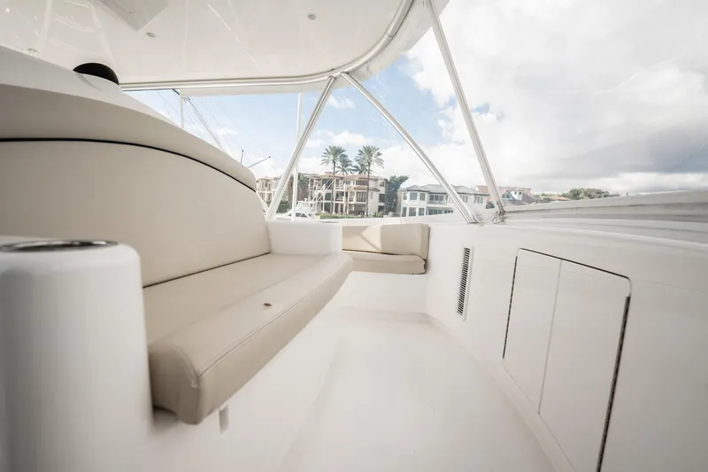 Slide: The Image of Luxurious interior of 2021 Viking 54 Convertible yacht with beige seating and panoramic windows. - 54