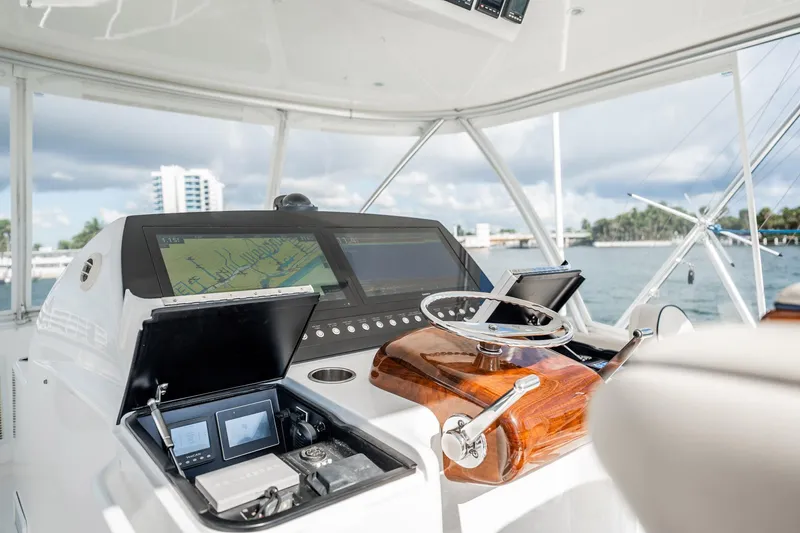 Slide: The Image of 2021 Viking 54 Convertible yacht helm with navigation screens and controls. - 59