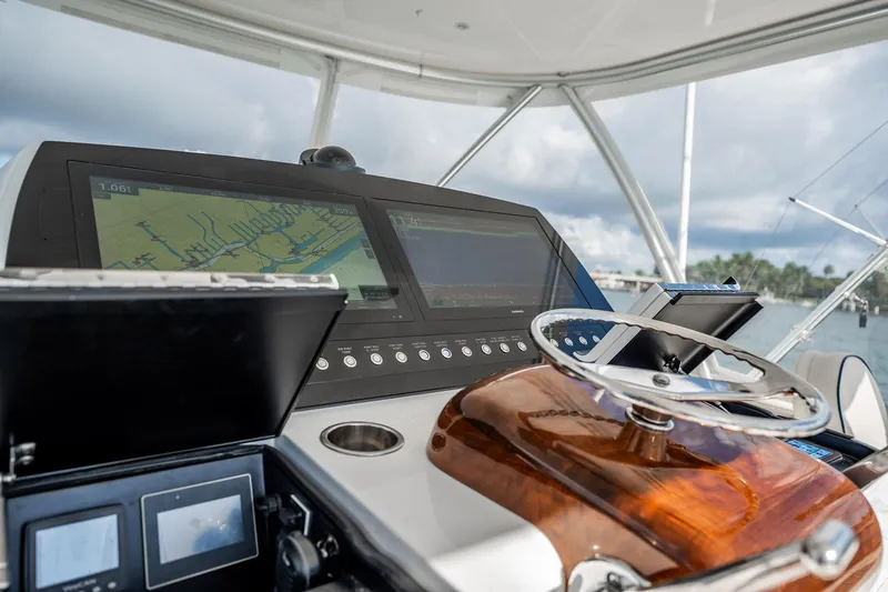 Slide: The Image of 2021 Viking 54 Convertible yacht helm with navigation screens and steering wheel. - 61
