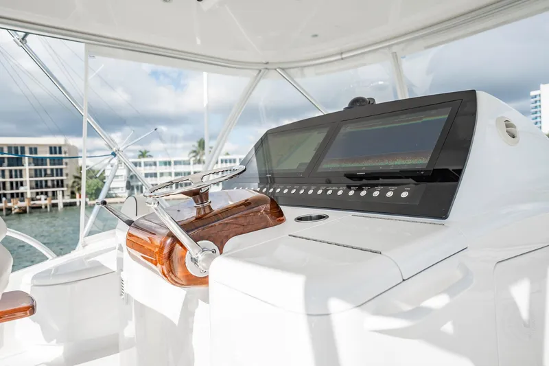 Slide: The Image of 2021 Viking 54 Convertible yacht helm with modern navigation displays and controls. - 65