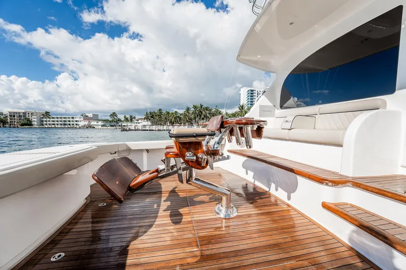 Slide: The Image of Luxurious 2021 Viking 54 Convertible yacht deck with polished wood and seating. - 80