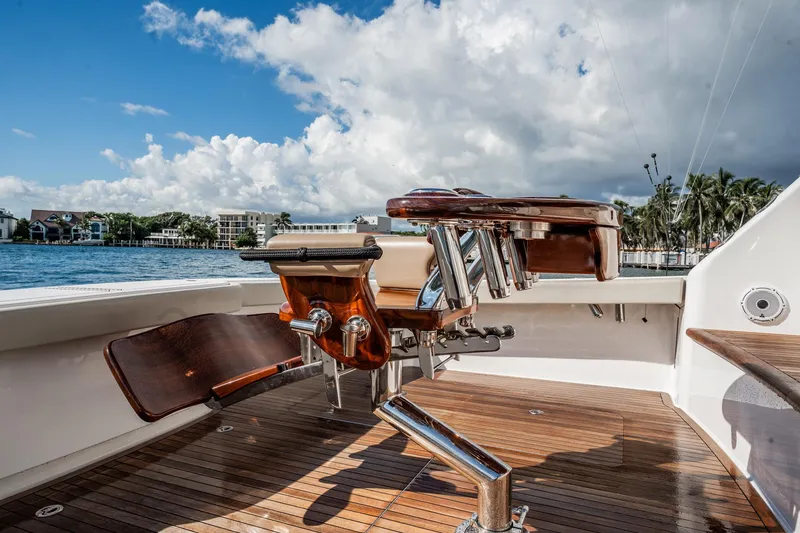 Slide: The Image of 2021 Viking 54 Convertible yacht deck with fishing chair, overlooking scenic waterfront. - 82