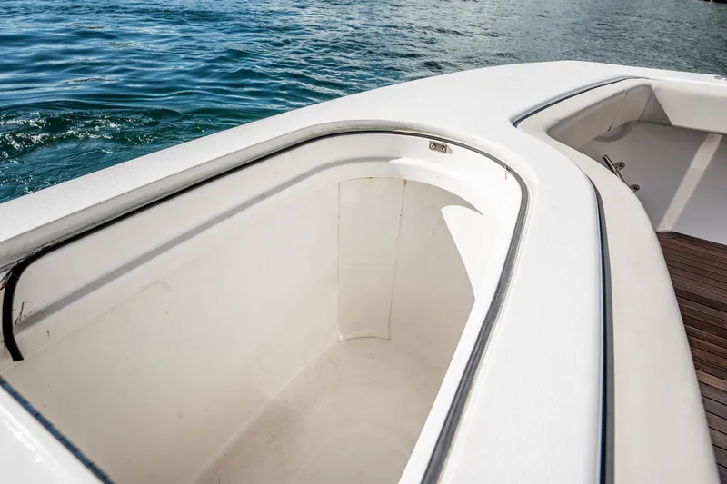 Slide: The Image of 2021 Viking 54 Convertible boat deck with storage compartment, near water. - 84