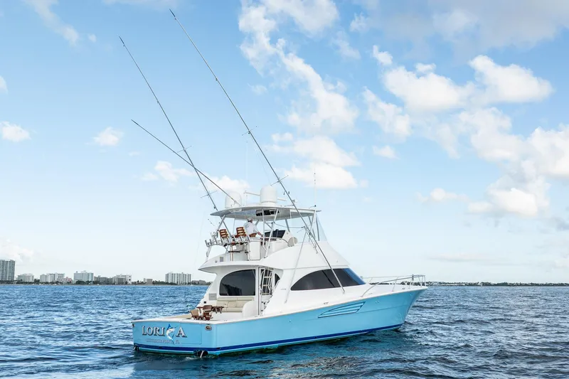Slide: The Image of 2021 Viking 54 Convertible yacht on open water under a clear blue sky. - 99