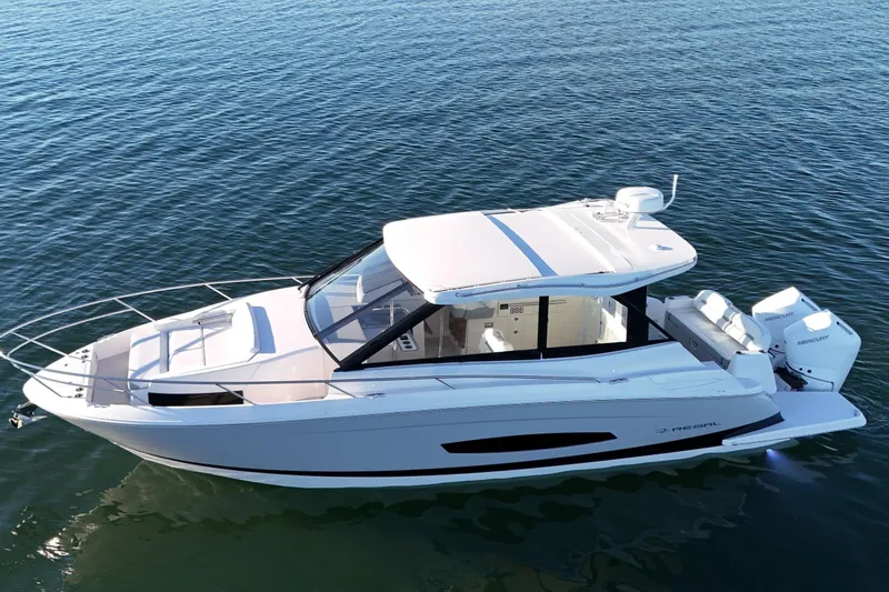 Slide: The Image of 2026 Regal 36 XO boat on calm water, showcasing sleek design and twin outboard engines. - 13