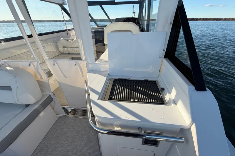 Slide: The Image of 2026 Regal 36 XO boat with outdoor grill, spacious seating, and scenic water view. - 18