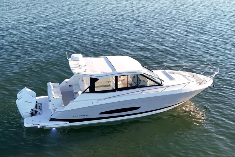 Slide: The Image of 2026 Regal 36 XO boat cruising on calm water, showcasing sleek design and modern features. - 2