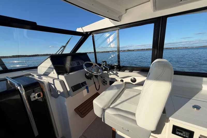 Slide: The Image of Helm of 2026 Regal 36 XO boat with scenic water view. - 22
