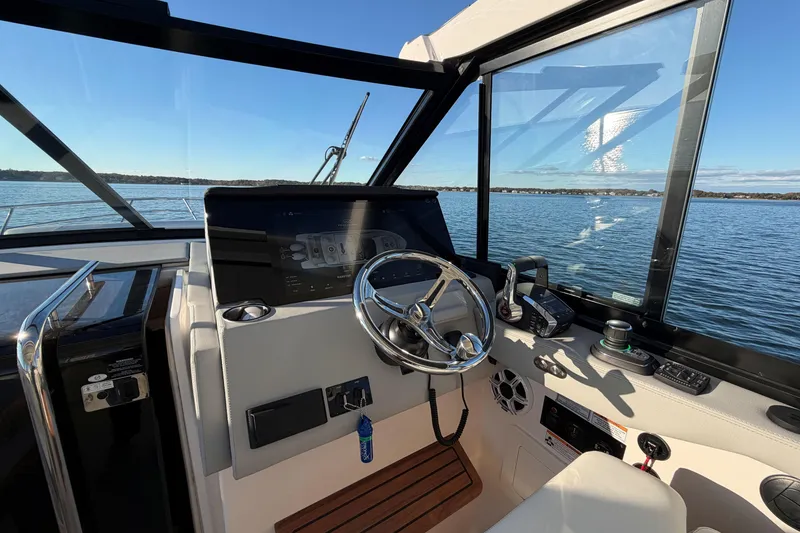 Slide: The Image of 2026 Regal 36 XO boat helm with modern controls and scenic water view. - 23