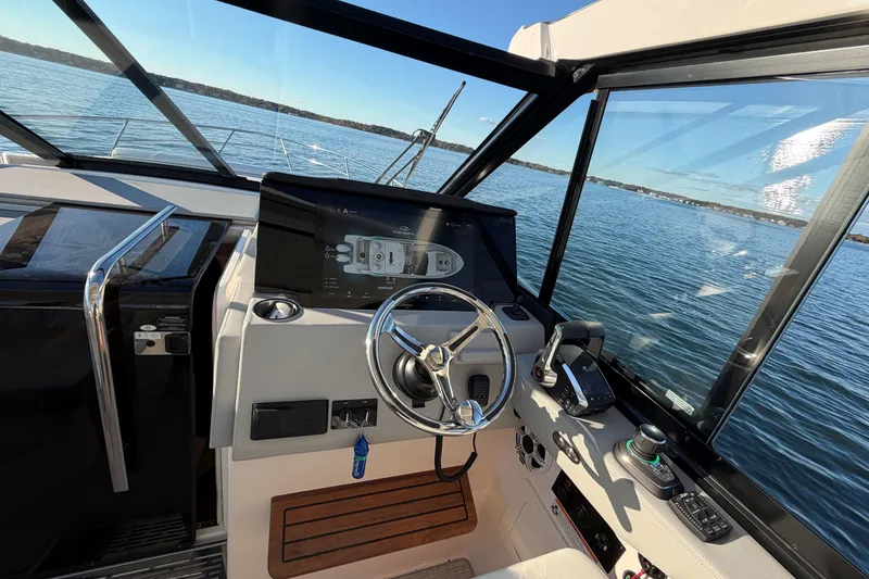 Slide: The Image of Interior view of 2026 Regal 36 XO yacht cockpit with steering wheel and control panel. - 24