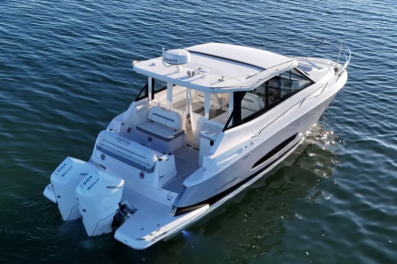 Slide: The Image of 2026 Regal 36 XO luxury boat cruising on calm waters, rear view. - 4