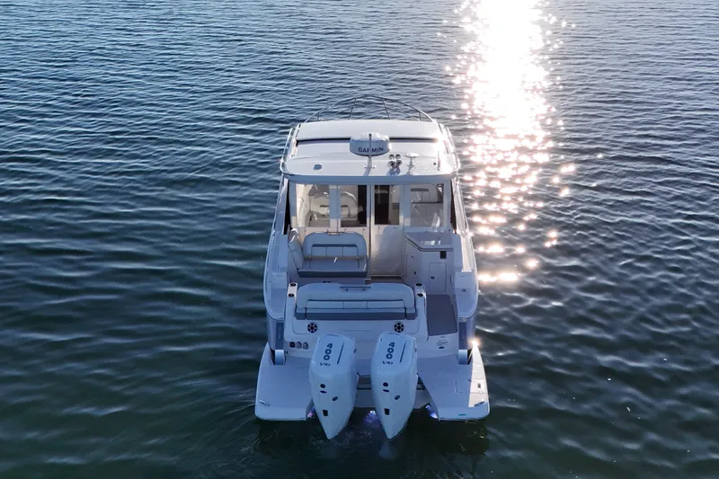 Slide: The Image of 2026 Regal 36 XO boat on water, reflecting sunlight, rear view. - 6