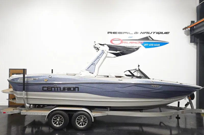 The Image of 2026 Centurion Nv243 boat on trailer in showroom, side view. - 1