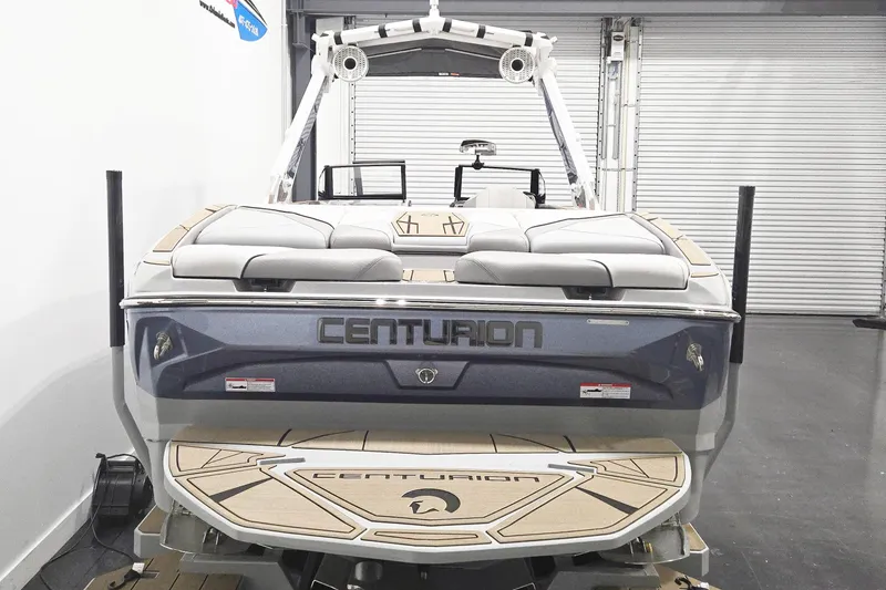 Slide: The Image of 2026 Centurion Nv243 boat, rear view in showroom, featuring sleek design and comfortable seating. - 5
