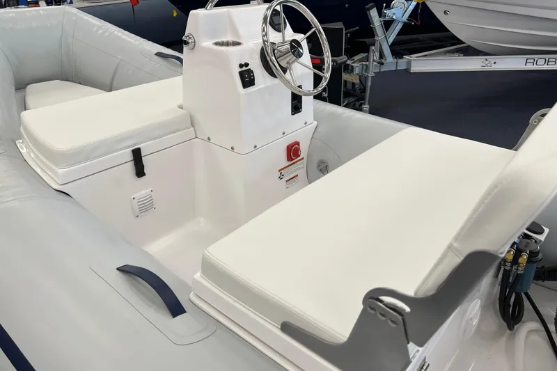Slide: The Image of 2023 AB Inflatables Mares 12 VSX boat interior with white seating and steering console. - 4