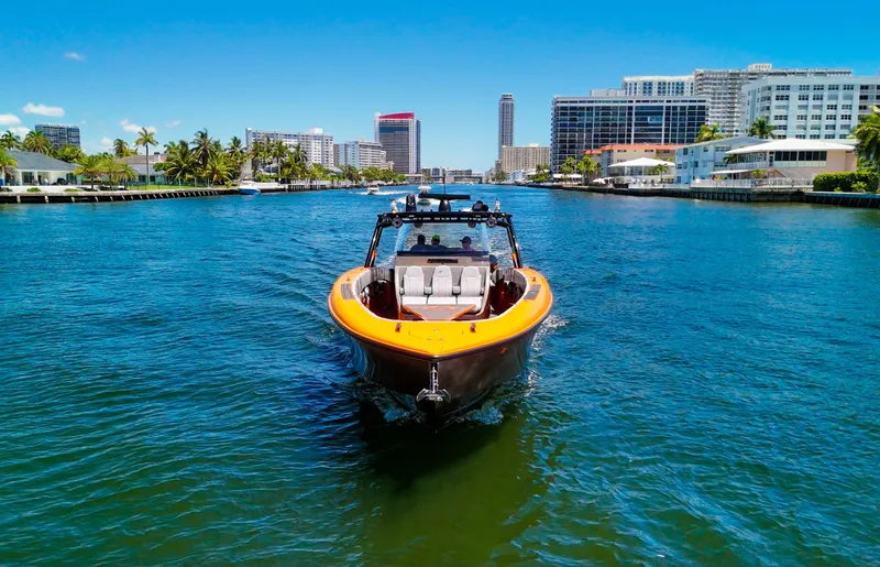 Slide: The Image of 2022 Midnight Express 43 Open boat cruising in a sunny urban waterway. - 13