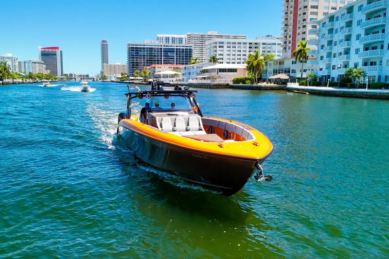 Slide: The Image of 2022 Midnight Express 43 Open boat cruising in a sunny urban waterway. - 14