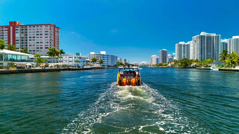 Slide: The Image of Midnight Express 43 Open boat cruising in a city waterway, surrounded by modern buildings. - 18