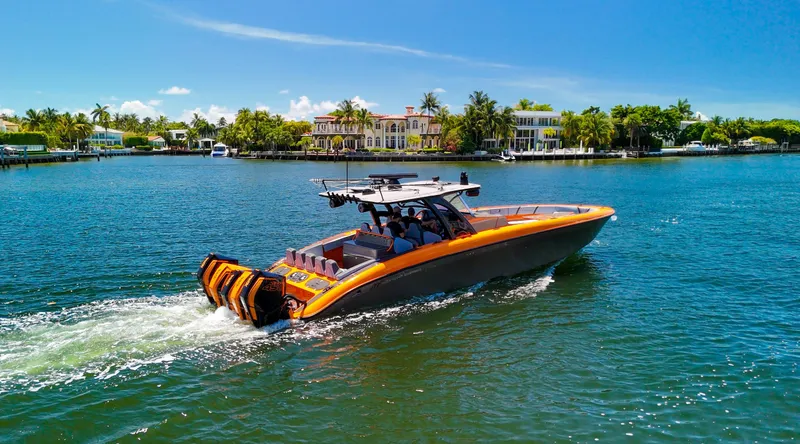 Slide: The Image of 2022 Midnight Express 43 Open boat cruising on a sunny day near waterfront homes. - 2