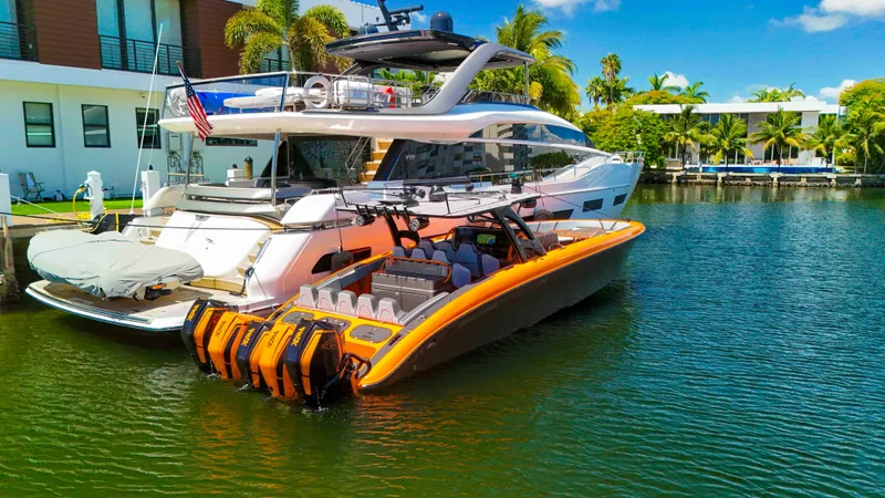 Slide: The Image of 2022 Midnight Express 43 Open boat docked beside a luxury yacht in a tropical setting. - 29
