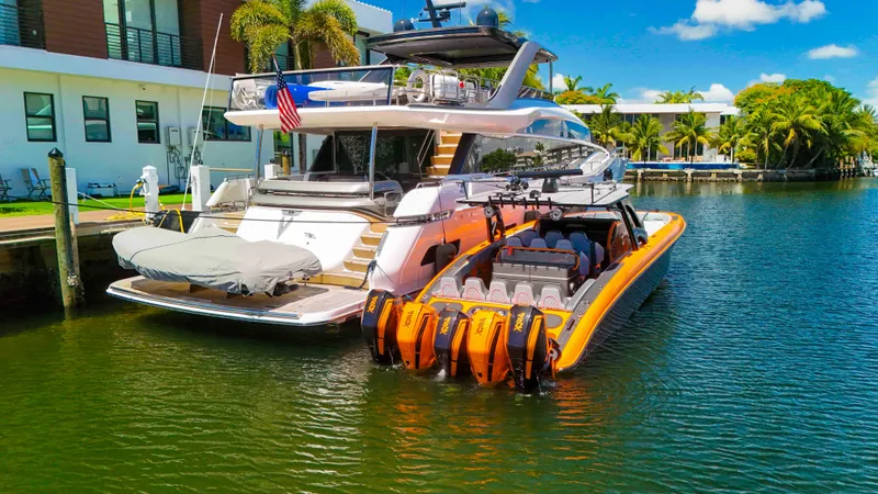 Slide: The Image of Luxury yacht docked with a 2022 Midnight Express 43 Open boat, featuring vibrant orange accents. - 30