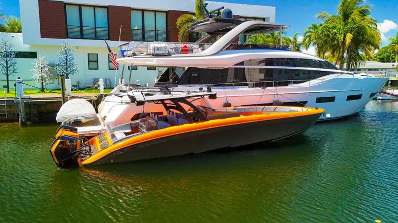 Slide: The Image of 2022 Midnight Express 43 Open boat docked beside a luxury yacht in a sunny marina. - 31