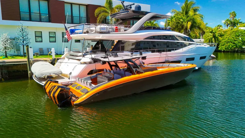 Slide: The Image of 2022 Midnight Express 43 Open boat docked beside a luxury yacht in a tropical setting. - 32