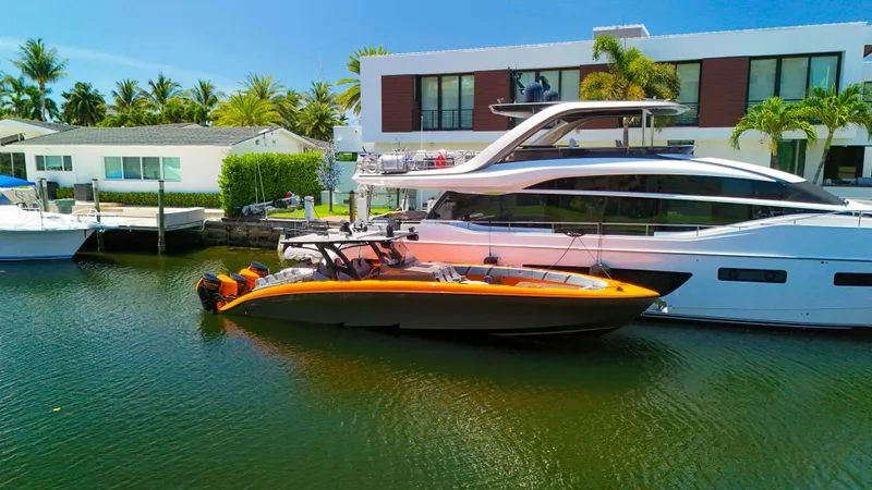 Slide: The Image of 2022 Midnight Express 43 Open boat docked beside a luxury yacht in a sunny marina. - 33