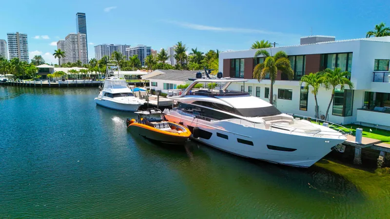 Slide: The Image of Luxury yachts docked by waterfront homes, featuring a 2022 Midnight Express 43 Open. - 39
