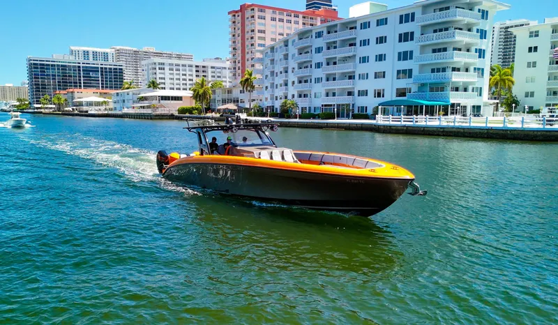Slide: The Image of 2022 Midnight Express 43 Open boat cruising near waterfront buildings. - 4