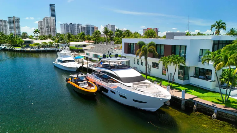 Slide: The Image of Luxury yachts docked by modern waterfront homes, featuring a 2022 Midnight Express 43 Open. - 40