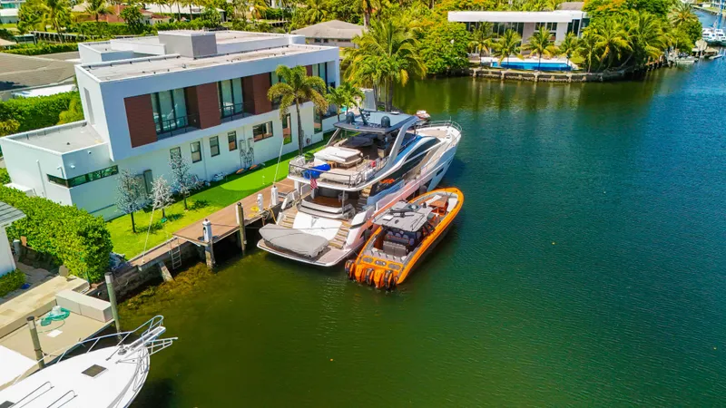 Slide: The Image of Luxury yachts docked by modern waterfront home, featuring 2022 Midnight Express 43 Open. - 43