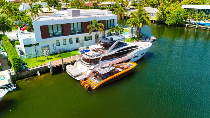 Slide: The Image of Luxury yacht docked beside modern waterfront home, featuring a 2022 Midnight Express 43 Open. - 44