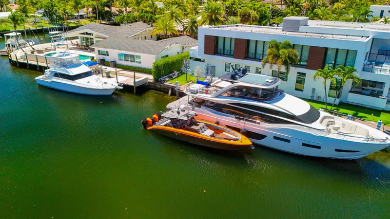 Slide: The Image of Luxury yachts docked by waterfront homes, featuring a 2022 Midnight Express 43 Open. - 46