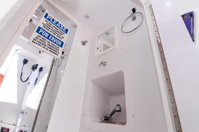 Slide: The Image of Interior of 2022 Midnight Express 43 Open boat bathroom with caution sign. - 48