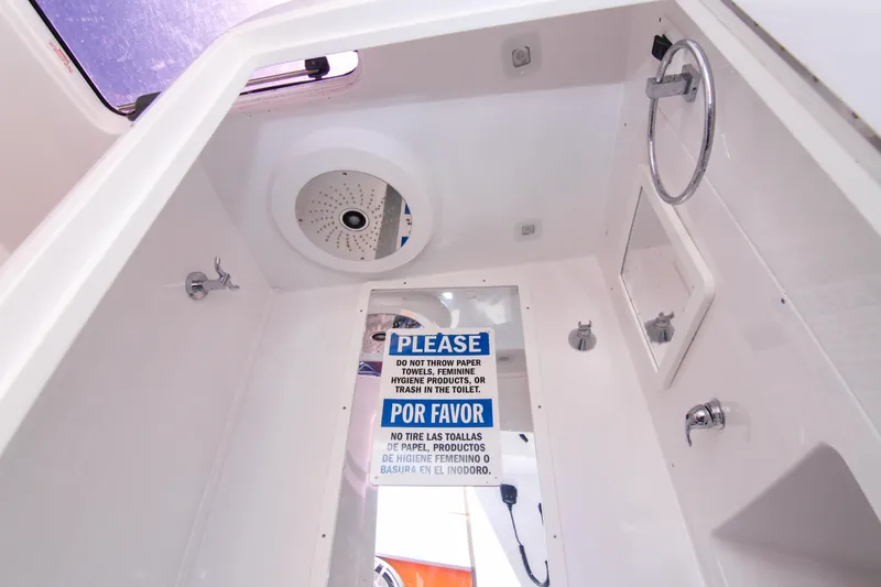 Slide: The Image of Interior of 2022 Midnight Express 43 Open boat bathroom with caution sign. - 49