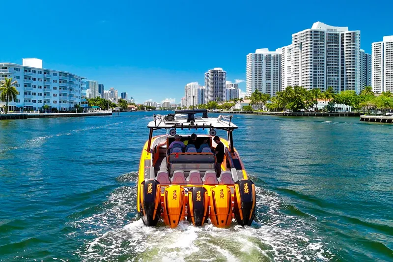 Slide: The Image of 2022 Midnight Express 43 Open boat cruising in a city waterway with skyscrapers. - 6