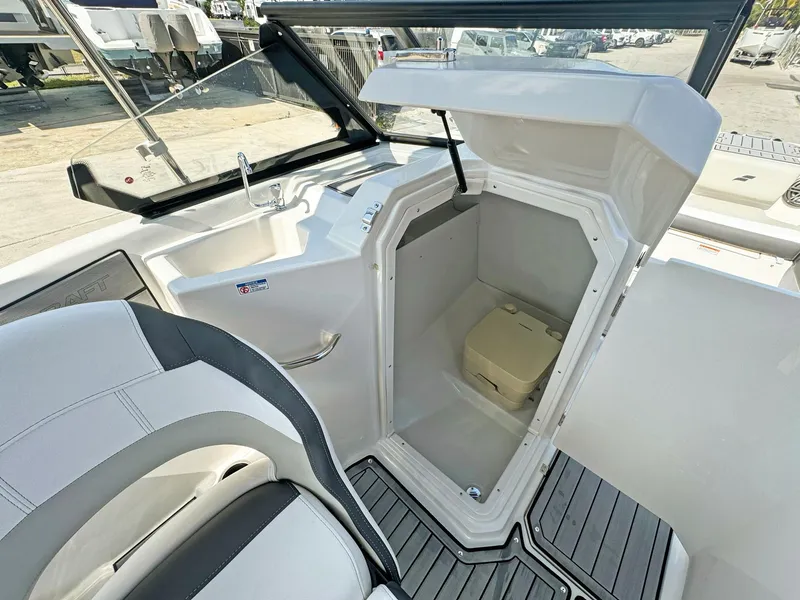 Slide: The Image of 2024 Starcraft SVX 230 OB boat interior with open storage compartment and seating. - 14