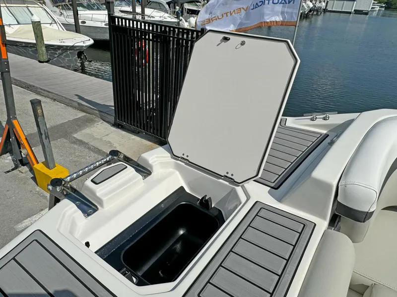 Slide: The Image of 2024 Starcraft SVX 230 OB boat storage compartment open by the dock. - 19