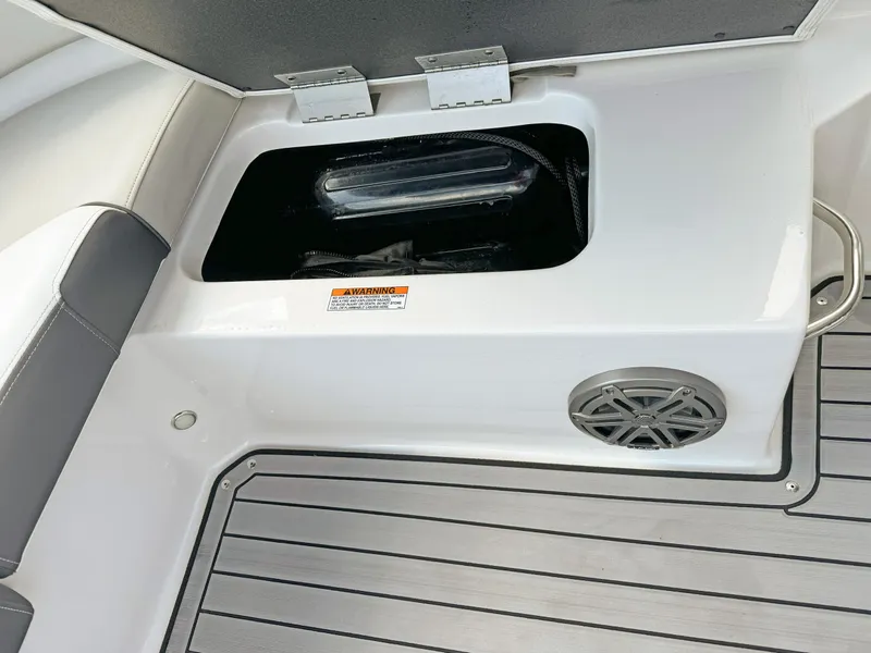 Slide: The Image of 2024 Starcraft SVX 230 OB boat interior with storage compartment and speaker. - 24